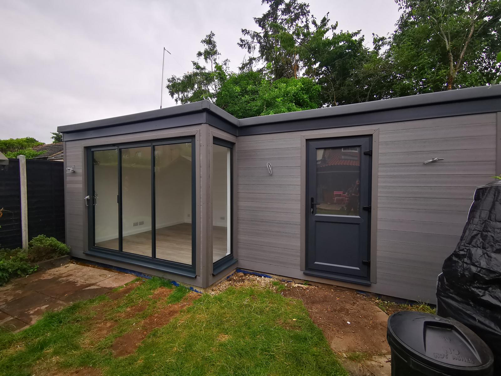 Grey-clad garden room with separate storage access